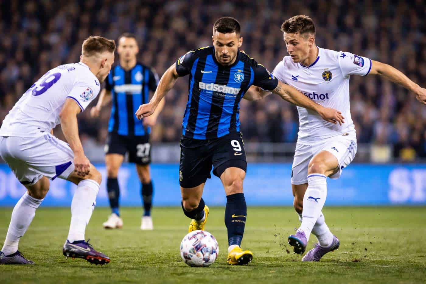 Joueur du Club Brugge dribblant face à deux défenseurs d’Anderlecht lors du match de Jupiler Pro League du 8 mars 2026.